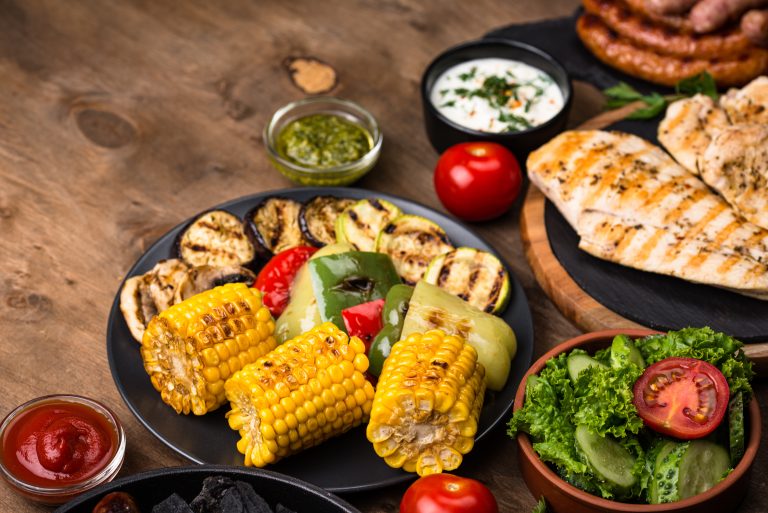Assortment of grilled sausages, meat, and vegetables. Picnic barbeque concept